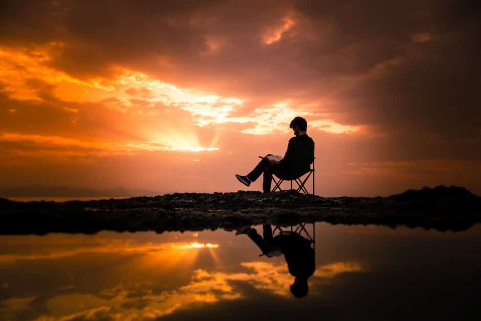 Image of a person sitting in a lightweight camping chair surrounded by nature.